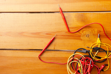 An assortment of cables are laying on a wooden surface