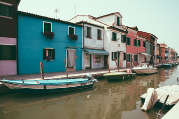 Fototapeta na wymiar Panoramic view of coloured homes and water canal with boats in Burano