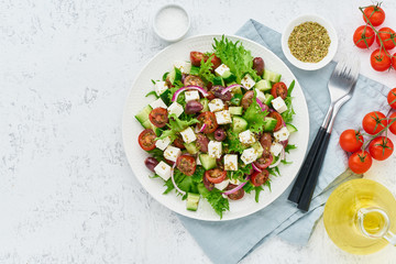 Greek Salad with feta and tomatoes, dieting food on white background copy space top view