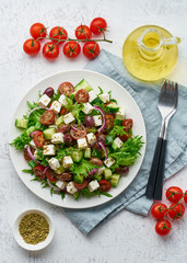 Greek Salad with feta and tomatoes, dieting food on white background vertical top view