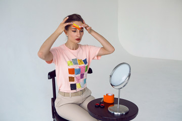 young girl beautician paste on the face of kinesio tape