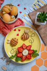 Pancake with fruits look like a flower and bees for kids breakfast