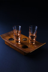 glasses of vodka or cognac on a brown wooden stand