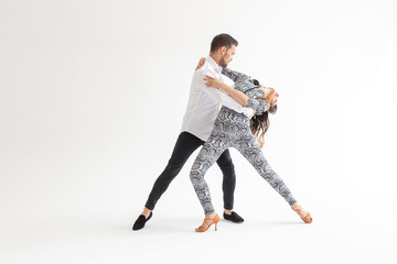 Social dance concept - Active happy adults dancing bachata together over white background with copy space