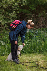 Young woman with a golden retriever in a hike