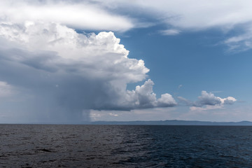 Calm tropical sea under darkening storm storm clouds