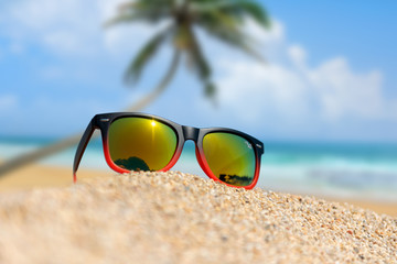 Fototapeta na wymiar Mirrored sunglasses close up on the beach sand
