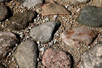 The road, a pedestrian path made of stones of different shapes