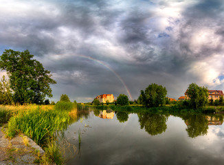 Beautiful rainbow and storm clouds over the lake, on the last day of spring, in Biskupice Podgorne...
