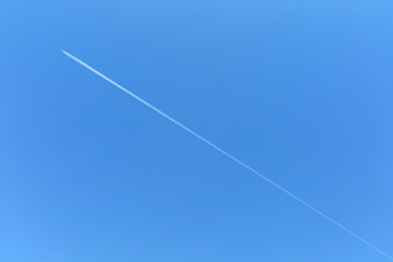 Bright blue sky with a strip from an airplane, background