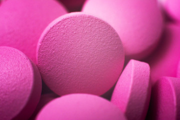 Macro pink pills. Close up. Pile of many pink drug pills laying in a pile. Medical background.
