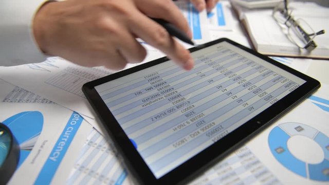 Businessman working with tablet pc, calculating, reading and writing reports. Office employee, table closeup. Business financial accounting concept.