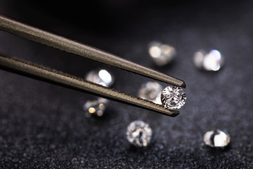 Small diamond in tweezers, close-up