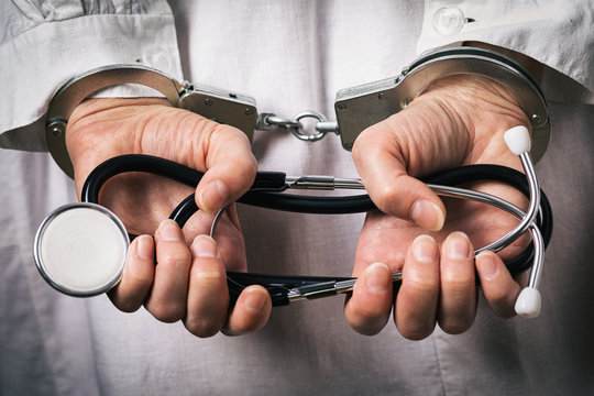 Handcuffed doctor. Medical crime concept, closeup