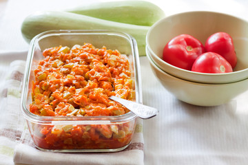 Squash stew with carrot and tomatoes in a square glass dish