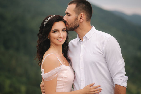 Close up portrait of beautiful couple in mountains. Happy woman with man. Elegant female with her husband