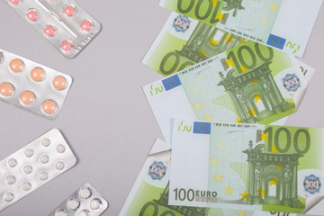 Money euro banknotes and pills. Expensive medical services