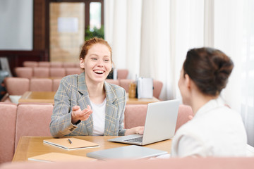 Cheerful ladies chatting in cafe