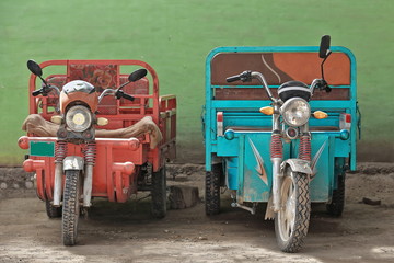 Obraz premium Red and blue three-wheelers in the Livestock Market area. Hotan-Xinjiang-China-0184