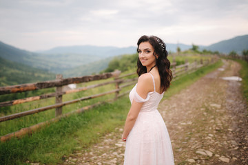 Charming bride in beautiful Carpathian mountais. Elegant woman in beautiful dress