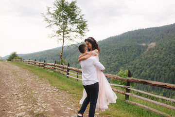 Groom kiss his beautiful bride. Couple walking in mountains