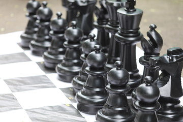 giant black and white chess figures on a chessboard