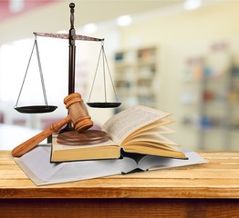 Man with glasses folded his arms and book, hammer and libra