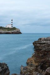 Fototapeta na wymiar The lighthouse of Portocolom on a cloudy morning, Mallorca, Spain - June 08, 2019
