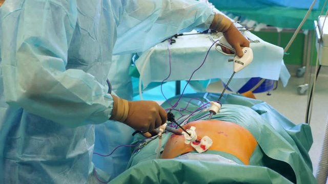 Surgeon uses medical tools while performing a surgery on a patient at a clinic.