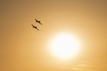 Airplanes flying at sunset. Orange sky background