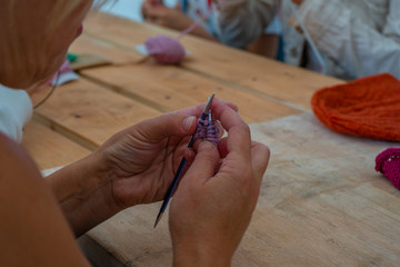 New hobby. Woman learns to knit at the master class. Learn 