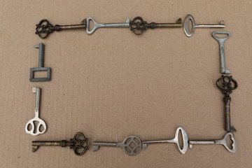 Fototapeta na wymiar Mettalic vintage keys on the brown background, figures from keys