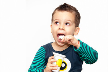 little kid eating yogurt on white background