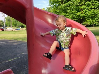 Little Boy Going Down a Slippery Slide