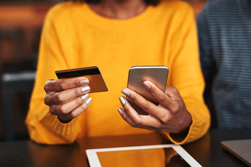 Woman in a cafe shopping online with credit card