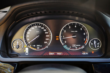 Electronic dashboard of modern luxury car with electronic display and with white arrows speedometer...