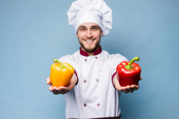 Food service, organic food, healthy diet, cooking and professional culinary concept - chef in white uniform holds vegetables.