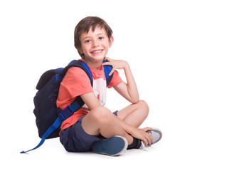 Happy smiling school boy siitting on the floor, isolated on a white background © cristovao31