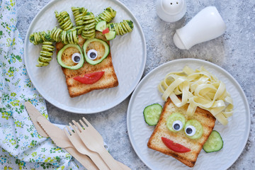 Lunch for children. Pasta with sandwiches and vegetables. Cheerful face.