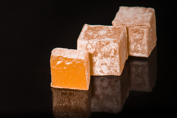 lokum Turkish delight, sweets on a black background (dessert sweets). food background. top view. copy space