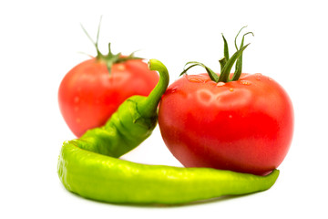 ripe fresh organic tomatoes in drops of dew and green hot chili pepper isolated on white background