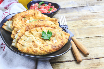 Latin American homemade fried empanadas with tomato sauces on wooden background. Selective focus