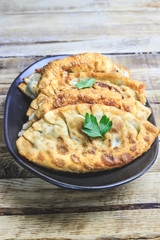 Latin American homemade fried empanadas with tomato sauces on wooden background. Selective focus