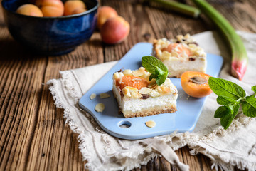 Apricot cheesecake with rhubarb, topped with crumble and almond flakes