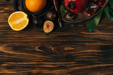 top view of fresh exotic fruits and hookah on wooden surface