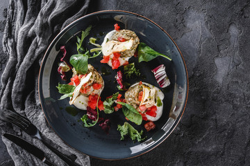 Healthy salad of grilled eggplant, arugula, spinach, tomato, croutons and sauce in a ceramic plate over grey background. Healthy vegan food, clean eating, dieting, top view