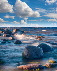 Long Exposure waves at the Ladoga lake. Beautiful scape with stone beach, reeds and water. Ladoga lake, Karelia, Russia.