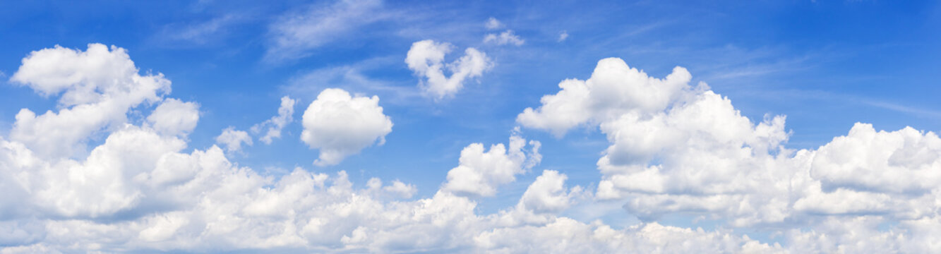 Panorama of a summer sky with fanciful cumulus clouds