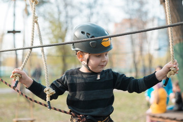 A little boy is passing an obstacle course. Active physical recreation of the child in the fresh air in the park. Training for children.