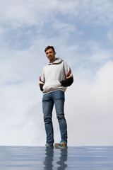 Young And Slim Man Observing From Above With Sky Background, Dressed In Casual Clothes